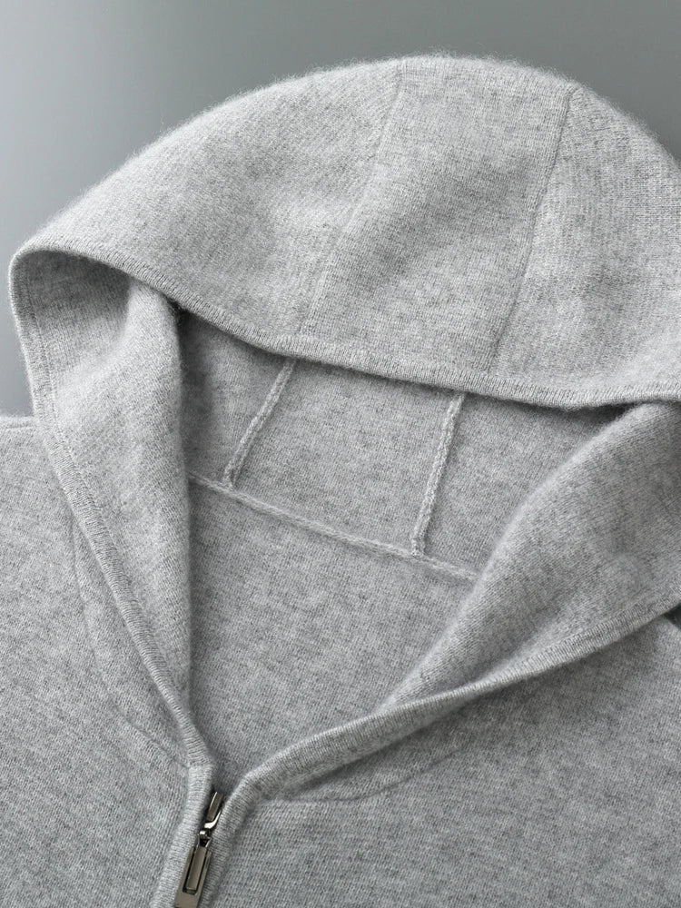 A close-up view of a light gray zip-up hoodie laid flat, highlighting the hood, zipper, and soft, textured fabric—perfect for layering as an autumn winter sweater.