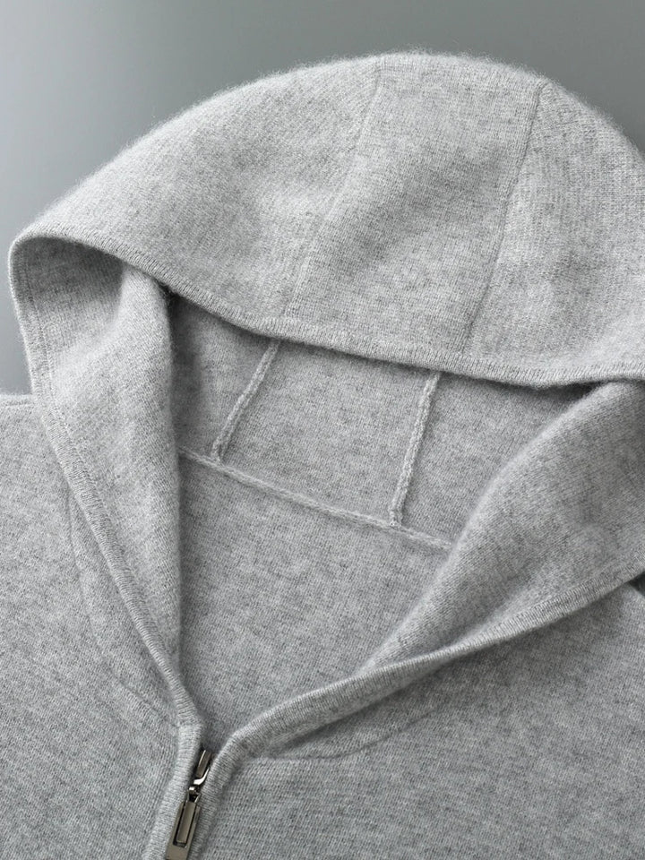 A close-up view of a light gray zip-up hoodie laid flat, highlighting the hood, zipper, and soft, textured fabric—perfect for layering as an autumn winter sweater.