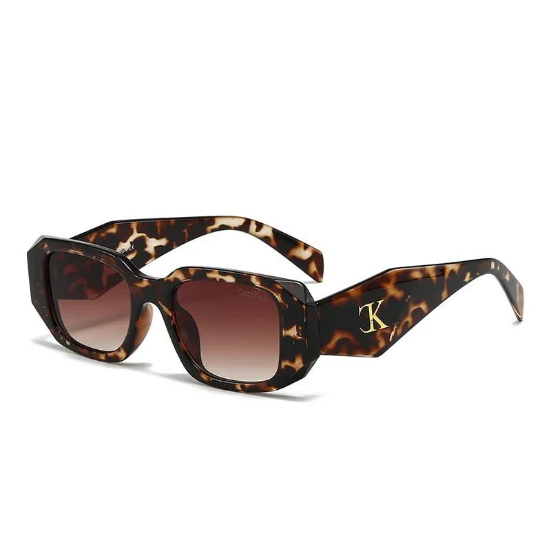Oversized acetate sunglasses with a tortoiseshell pattern, rectangular thick frames, and brown gradient lenses. Reinforced hinges and UV400 protection offer durability and eye safety. The left arm features a gold K logo detail near the hinge.