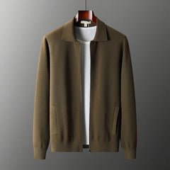 A brown zip-up merino wool jacket with a collar is displayed on a hanger over a plain white t-shirt, set against a plain gray background, offering natural temperature regulation.