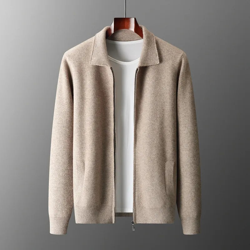 Beige zip-up cardigan with a collar, long sleeves, and two side pockets, crafted from moisture-wicking merino wool, displayed on a wooden hanger over a plain white t-shirt against a gray background.