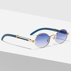 Round vintage sunglasses with gold frames and blue gradient lenses, featuring dark blue temples with gold accents. These Nautical Shades offer UV400 protection and are displayed on a white and gray surface with soft shadows.