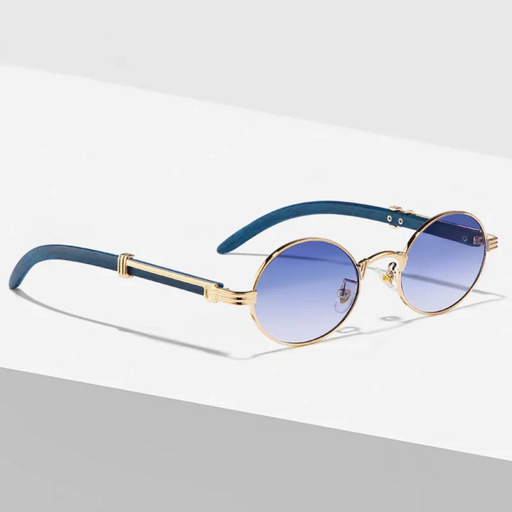 Round vintage sunglasses with gold frames and blue gradient lenses, featuring dark blue temples with gold accents. These Nautical Shades offer UV400 protection and are displayed on a white and gray surface with soft shadows.
