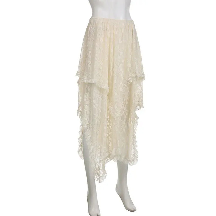 A mannequin wearing a cream-colored, high waist skirt with silky lace layers and an asymmetrical hemline, featuring sheer, delicate fabric that drapes in soft waves.