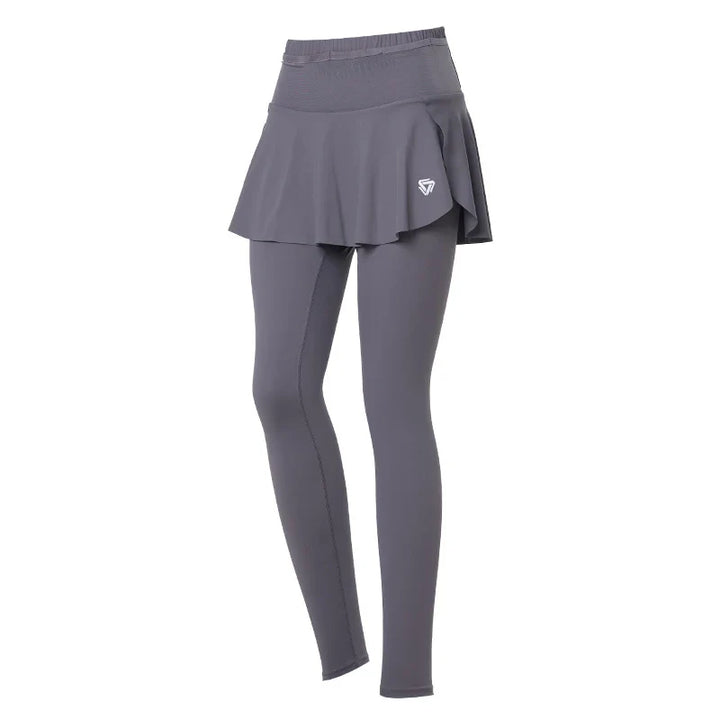 Gray skirted leggings with high-waisted support and an attached skirt overlay, featuring a small white logo on the left side. The athletic design is displayed on a plain white background.