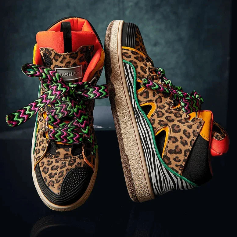 A pair of colorful, lightweight animal print shoes with leopard and zebra patterns, neon orange accents, durable rubber soles, and thick multicolored shoelaces. The sneakers stand out boldly against a dark background.