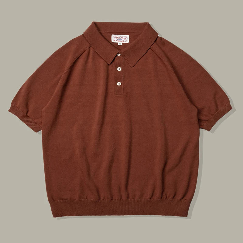A short-sleeved brown organic cotton polo with a ribbed hem and sleeves, three white buttons, and a classic collar, laid flat on a neutral gray background.