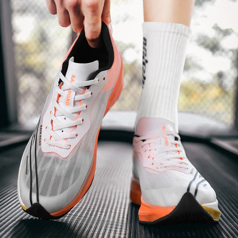 A person wearing white athletic shoes with orange soles and white socks stands on a treadmill, adjusting the heel of one shoe. The shoes feature a sleek, modern design with lightweight construction for maximum comfort.