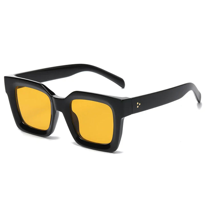Black, thick acetate square-framed sunglasses with bright yellow lenses offer UV protection. Shown at an angle on a white background, the temple arms are accented by three small gold dots at the hinge.