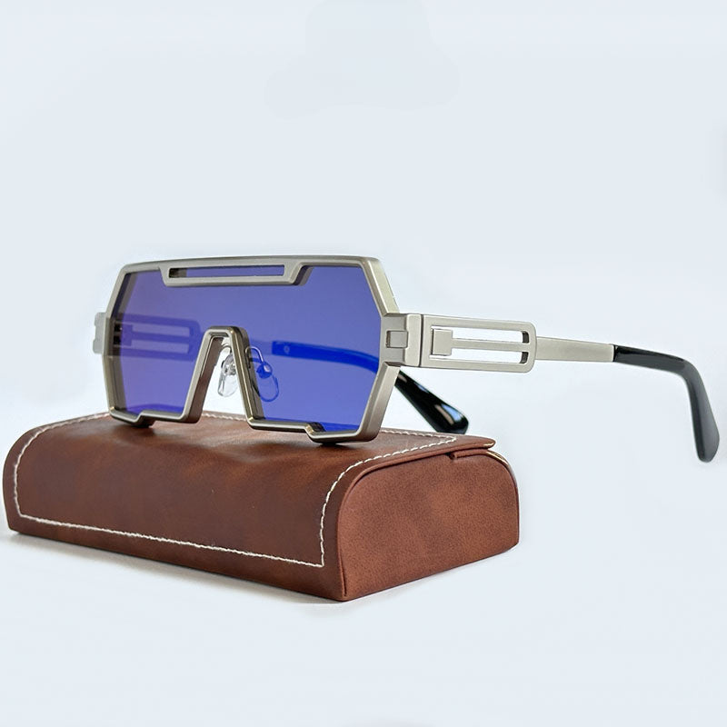 Futuristic sunglasses with blue-tinted rectangular lenses and geometric silver square frames, resting on a brown leather case against a light background.