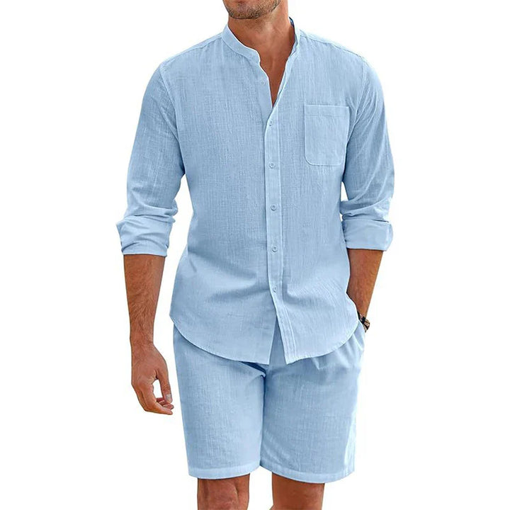 A man wears a light blue Vintage Stand Collar Shirt with a chest pocket and matching baggy shorts. The Cotton Linen Outfit creates a casual, summery vibe, while the mans face remains out of view.