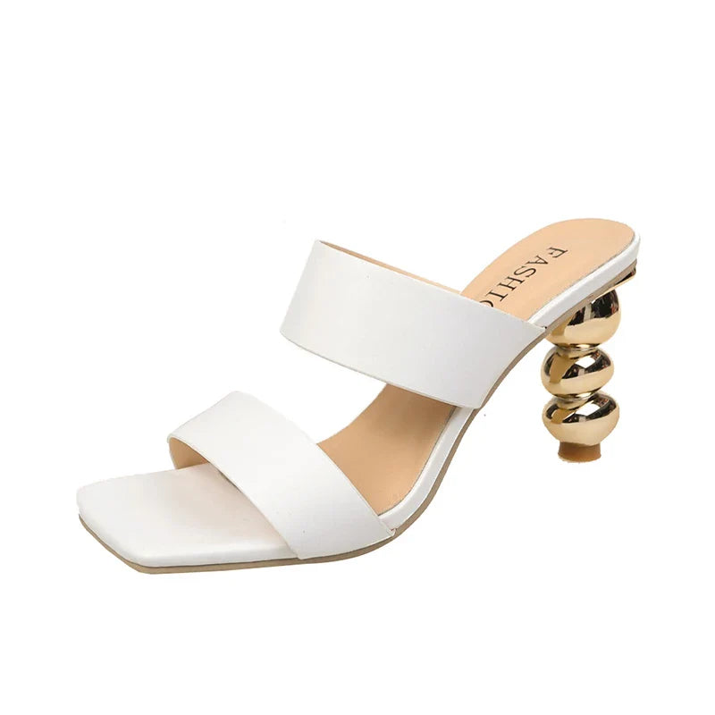 A stylish white heeled sandal crafted from premium leather, featuring two wide straps, a square toe, and a unique gold spiral-shaped heel.