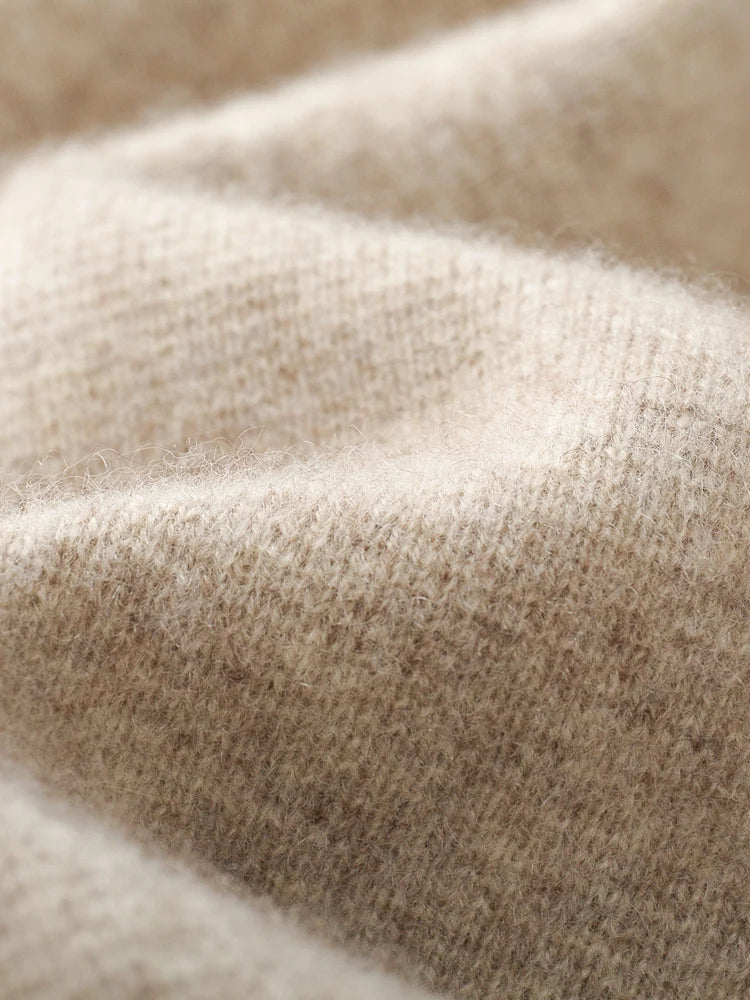 Close-up of a soft, beige wool cardigan fabric, showing its textured, fuzzy surface with gentle folds and subtle shadows—perfect for a cozy autumn winter sweater.