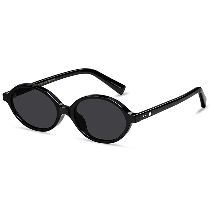 Black round sunglasses with thick, lightweight acetate frames and dark tinted lenses, featuring UV400 protection. Shown at an angle on a white background, the slightly curved arms display a small X symbol near the hinges.