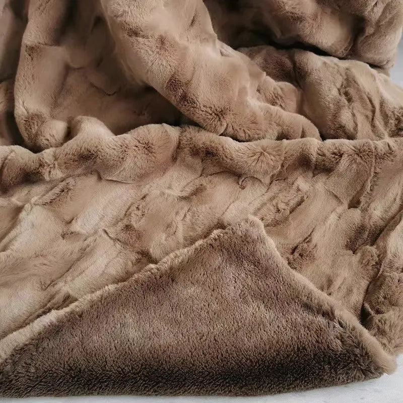 A close-up view of a soft, brown, plush faux fur blanket with a textured, cozy surface and folded edges, showcasing the warmth and comfort of this eco-friendly blanket.