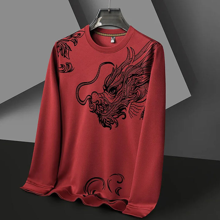 A red mens crewneck hangs on a hanger, featuring a large, detailed black dragon design across the front. The background consists of geometric gray shapes.