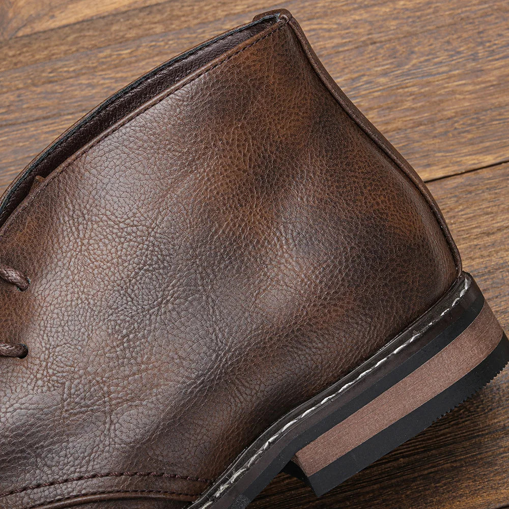 Close-up of a brown textured After-Ride Chukka on a wooden surface, highlighting intricate stitching details and a layered sole.