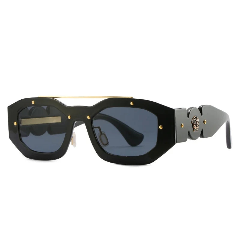Black geometric sunglasses with dark, scratch-resistant lenses, gold metal accents, and decorative gold details on the bridge and temples. The temples feature a circular gold emblem detail and provide UV400 protection.