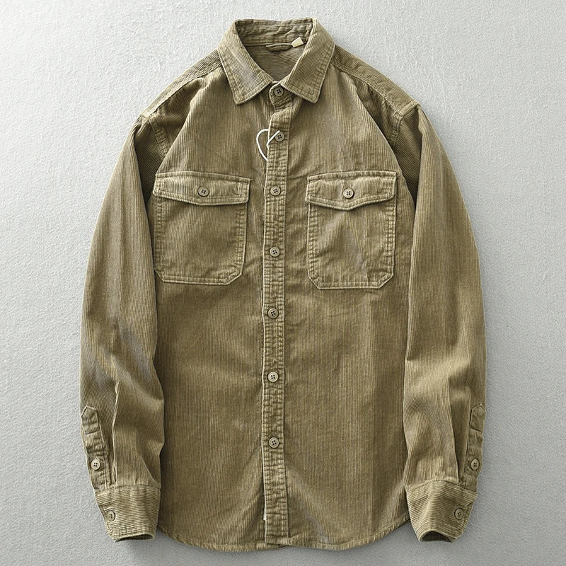 A khaki-colored, long-sleeve button-up shirt with two chest pockets and subtle corduroy detailing, displayed flat on a light gray surface.