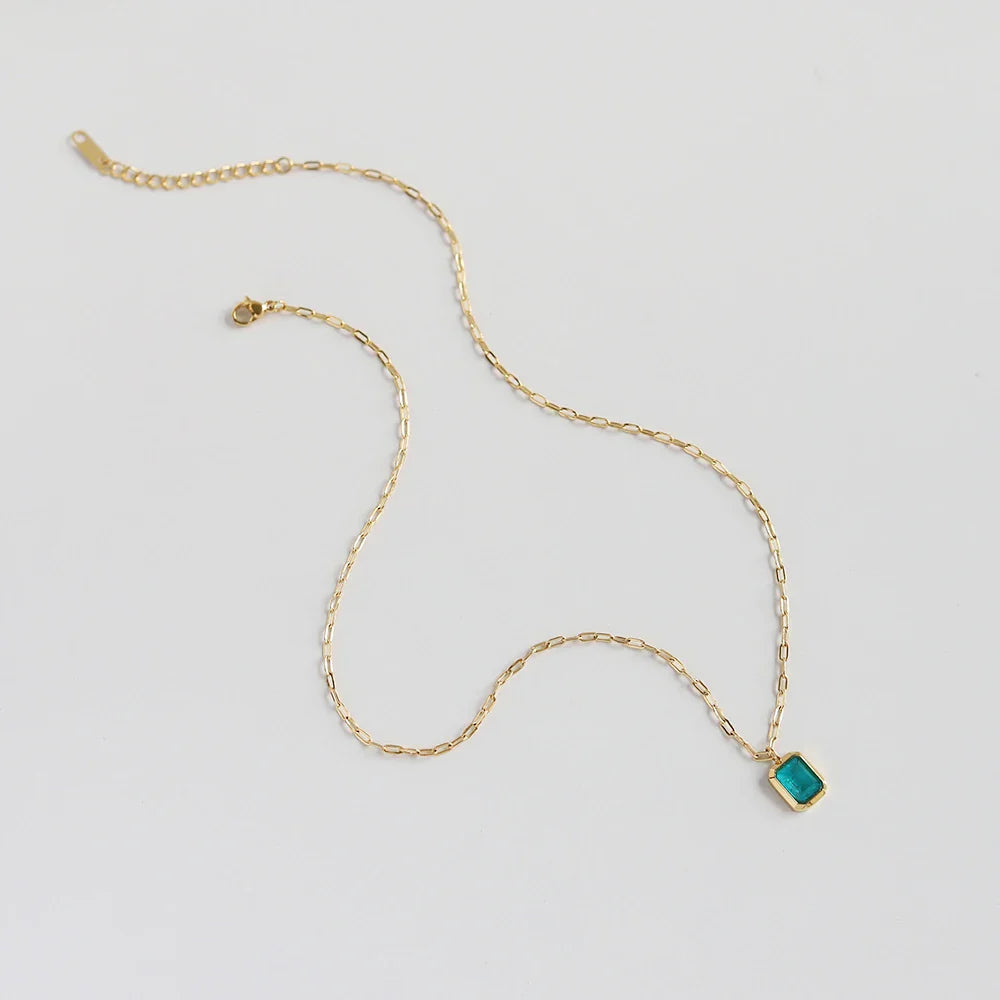 A delicate 18K gold plated chain necklace with a rectangular turquoise pendant, displayed on a plain white background.