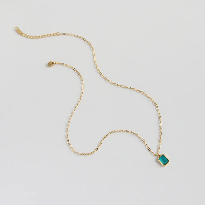 A delicate 18K gold plated chain necklace with a rectangular turquoise pendant, displayed on a plain white background.