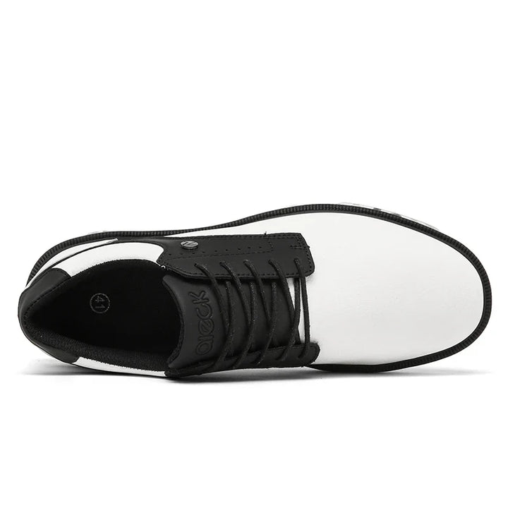 Top view of a white and black lace-up shoe with a rounded, reinforced toe cap, black laces, and a black tongue. The interior is black with a small circular logo visible near the heel area.