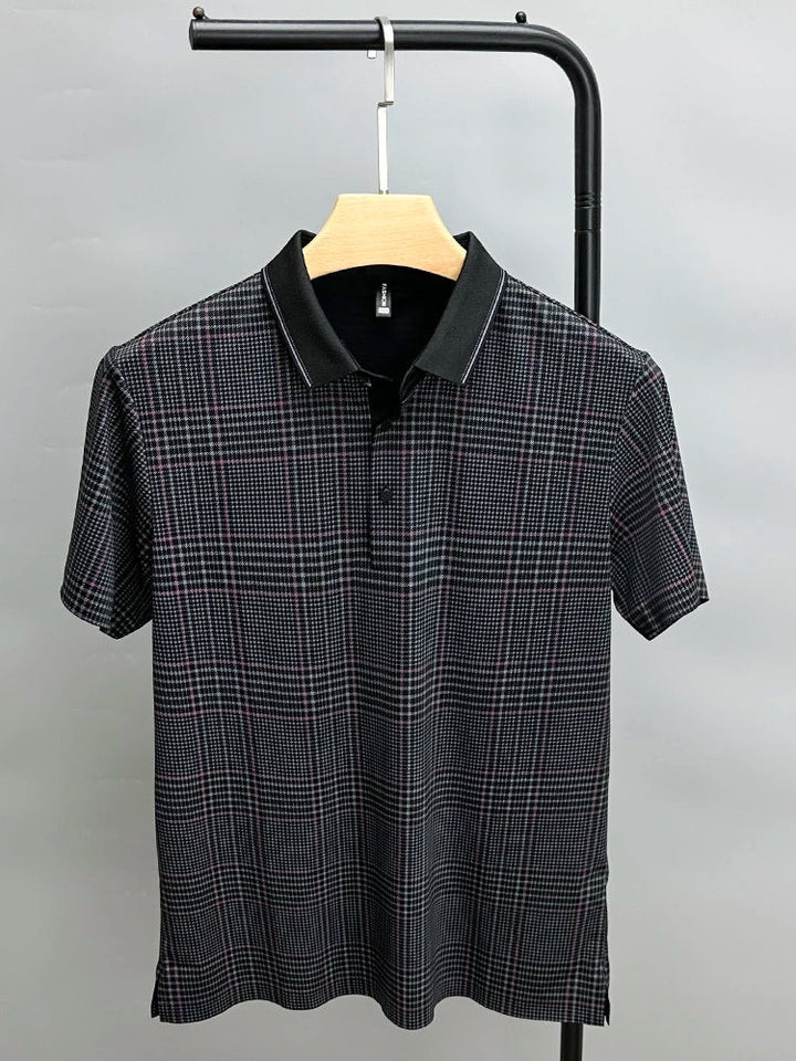 A black, breathable short-sleeve polo shirt with a subtle plaid pattern in white and red, hanging on a wooden hanger against a plain gray background.