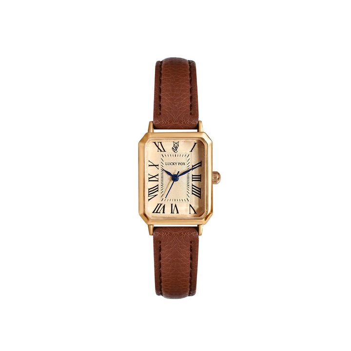 A gold Roman numeral watch with a rectangular face, genuine leather strap in brown, blue hands, and a cream-colored dial. The watch is centered on a plain white background.