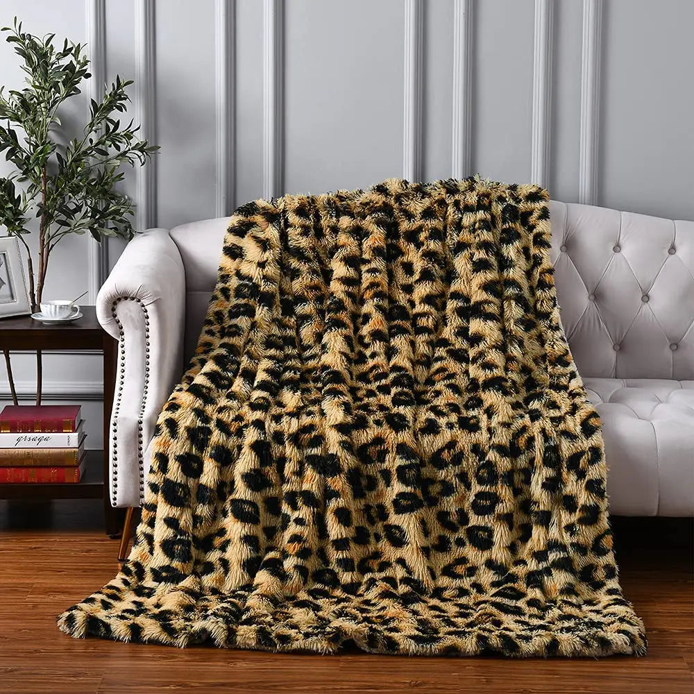 A plush throw leopard print blanket is draped over a tufted white sofa in a stylish living room with wood flooring and decorative panel walls, adding ultra-soft textile comfort and chic flair to the space.