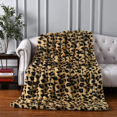 A plush throw leopard print blanket is draped over a tufted white sofa in a stylish living room with wood flooring and decorative panel walls, adding ultra-soft textile comfort and chic flair to the space.