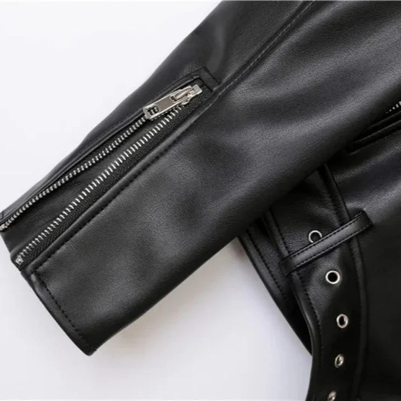 Close-up of the sleeve and side of a black leather jacket, featuring a silver zipper on the sleeve, zipper pockets, and metal eyelets with a strap detail on the side. The background is plain white.