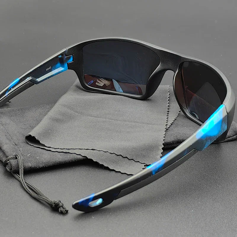 A pair of Everest Sunglasses with polarized lenses rests on a soft black pouch and cleaning cloth, displayed on a dark surface. The inside of the left lens reflects a hand holding a smartphone.