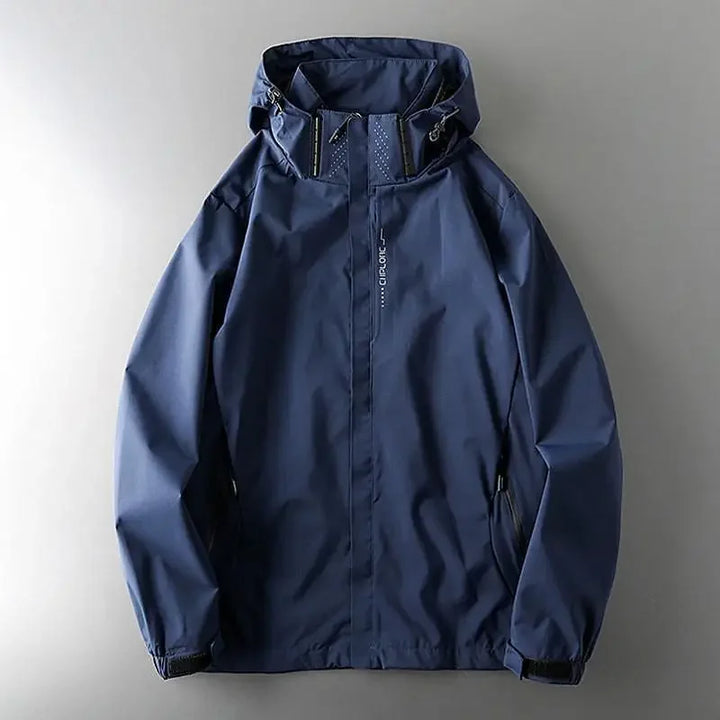 A navy blue windproof jacket with a hood, front zipper, two side pockets, and adjustable cuffs, displayed flat on a gray background.