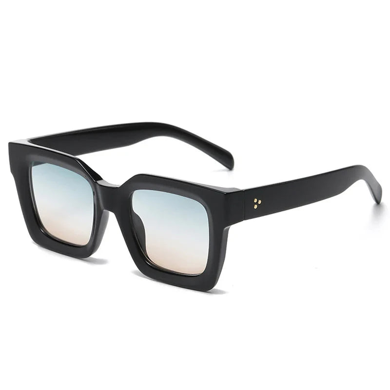 A pair of black, thick-rimmed square-framed sunglasses with acetate frames and lightly tinted gradient lenses—fading from blue at the top to pale brown at the bottom. The arms feature a small gold dot detail near the hinges for added style and UV protection.