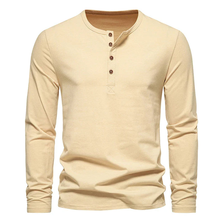 A beige long-sleeve Henley shirt with a classic design features four brown buttons on the front placket. Crafted from breathable cotton, its shown on a plain white background.