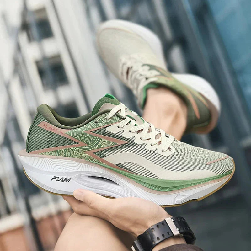 A person holds up a pair of light green running shoes with a shock-absorbing sole and subtle pink and green accents, showing the FLAM logo on the sole, against a blurred urban background.