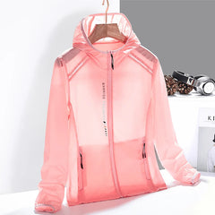 A light pink, semi-transparent hooded jacket made from quick-dry material is displayed on a hanger. The jacket has a front zipper, two zippered pockets, and is set against a minimal background with headphones and pine cones nearby.