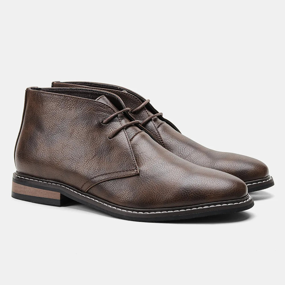 A pair of brown leather boots, the After-Ride Chukka features lace-up styling, a low heel, and stitched detailing on the sole, displayed on a plain white background.