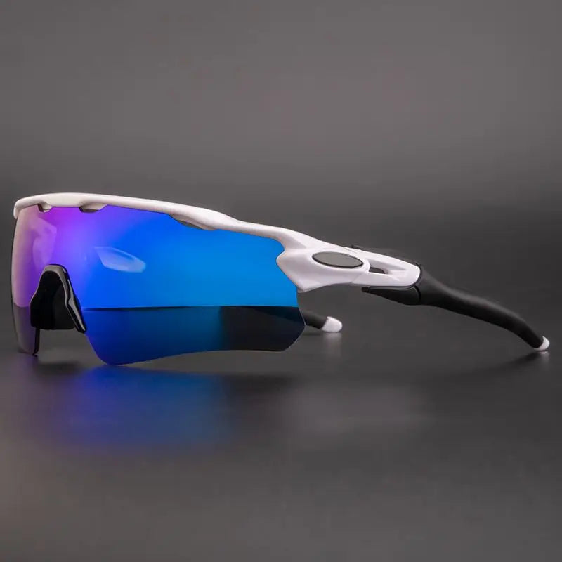 Sporty Polarized Cycling Sunglasses with a white and black frame and mirrored blue lenses offer UV Protection, displayed on a dark gray surface against a matching background.