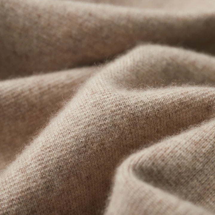 Close-up of soft, beige merino wool fabric with a textured, cozy surface and gentle folds, highlighting the material’s warmth, smoothness, and natural temperature regulation.