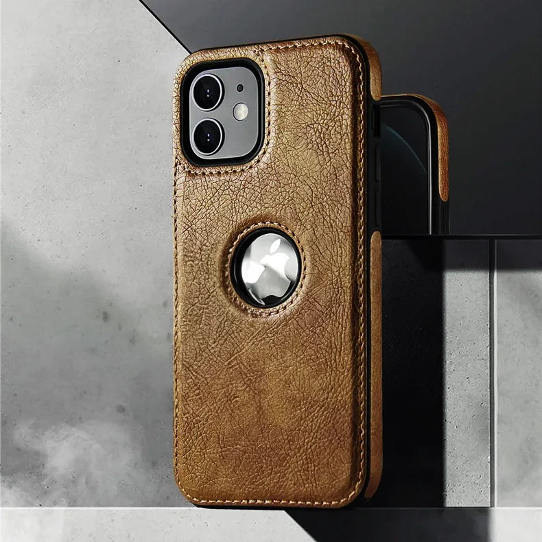 A luxury leather phone case in brown with a circular cutout reveals an Apple AirTag. This slim protective case, wireless charging compatible, props your iPhone stylishly against a gray and black tiled surface.