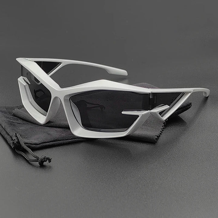 Futuristic, angular cycling glasses with silver geometric frames and high-contrast lenses, resting on a black drawstring pouch against a dark background.