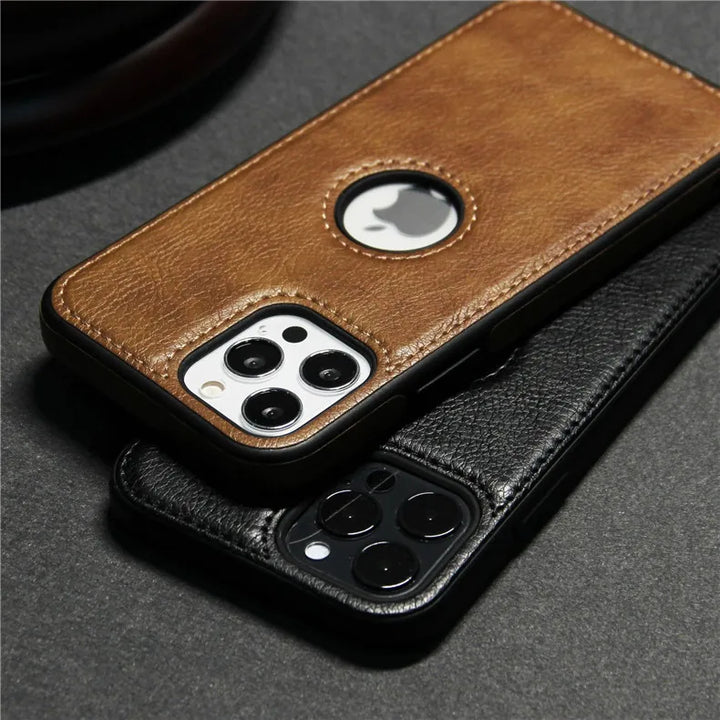 Two smartphones in slim protective cases, one brown and one black, rest on a dark surface. The brown luxury leather phone case has a circular cutout for the Apple logo. Both phones feature triple rear cameras and are wireless charging compatible.