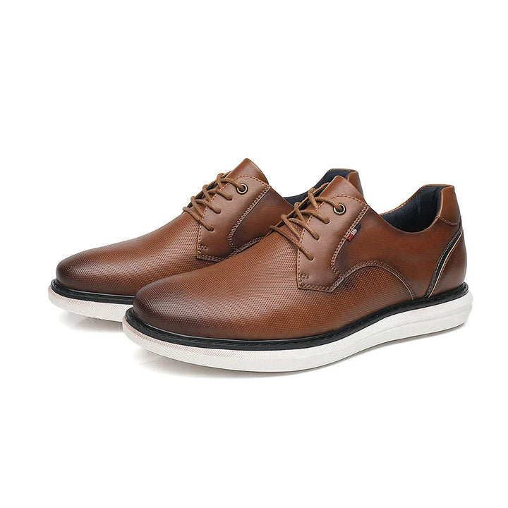 A pair of brown genuine leather oxford dress shoes with traditional detailing, white rubber soles, low heel, and subtle stitching accents, placed on a white background.