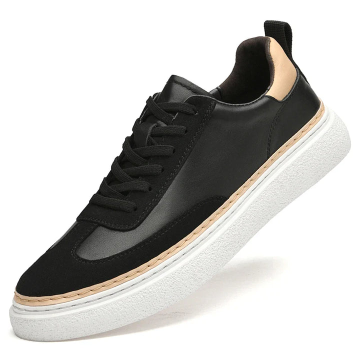 A black sneaker with black laces, a white textured sole, beige heel accent, and beige trim above the sole, crafted from genuine leather for durability and style, shown at an angle against a white background.