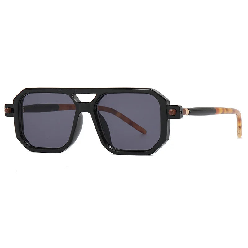 Geometric black sunglasses with dark lenses and thick, angular frames. This luxury eyewear features temples that are black near the hinges and transition to a light tortoiseshell pattern toward the ends.