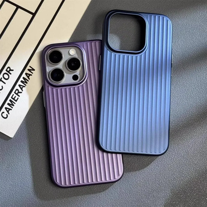 Two ribbed phone cases, featuring a slim lightweight design—one purple with a phone inside and one empty in blue—are placed on a gray surface next to a black and white clapperboard.