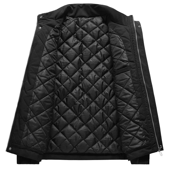 A black windproof jacket displayed open to show its quilted, diamond-patterned inner lining for added warmth and comfort. The jacket features zipper and snap button closures, along with adjustable cuffs for a customized fit.
