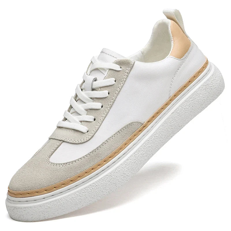 A white sneaker with light gray suede detailing, beige accent on the heel, white laces, and a thick white textured sole features arch support and a cushioned insole for enhanced comfort.