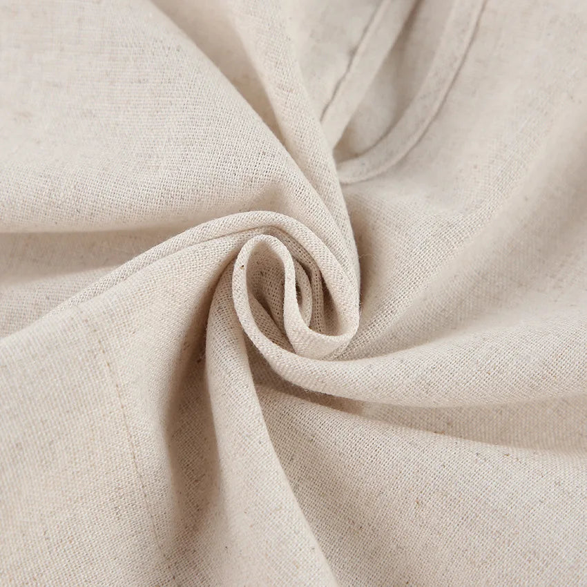 Close-up of a piece of natural beige Belgian Linen Blend fabric, gathered and twisted into a spiral shape, highlighting its texture and weave.